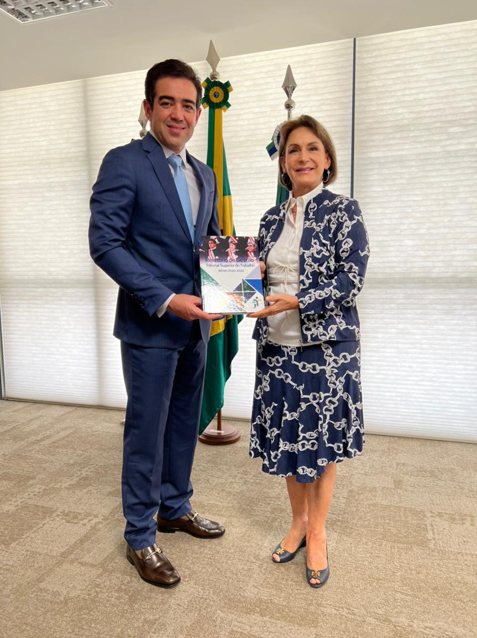 Ministro Bruno Dantas e Ministra Peduzzi posando com o relatório de gestão do TST