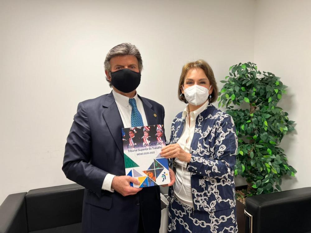 Ministro Luiz Fux e ministra Peduzzi posando com o relatório de gestão do TST