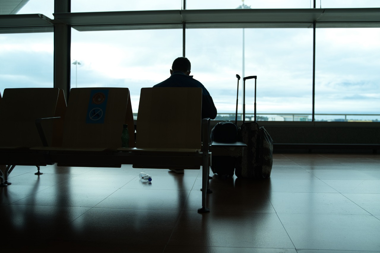 Imagem: homem sentado em banco de aeroporto