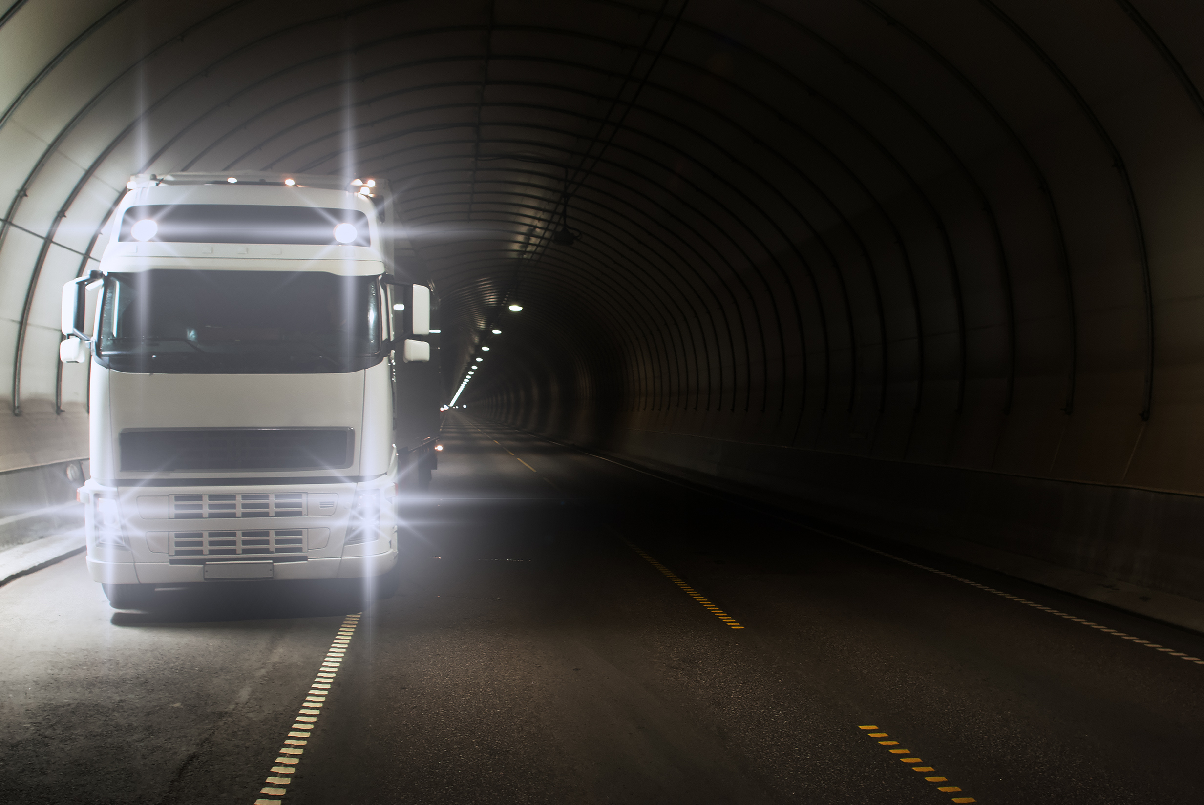 Imagem: caminhão passando por túnel, durante a noite