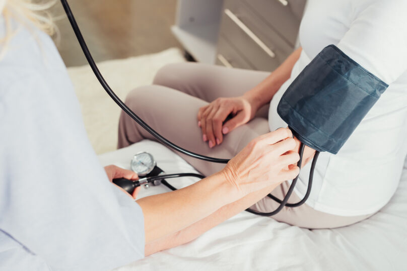 Mulher verifica pressão arterial de paciente