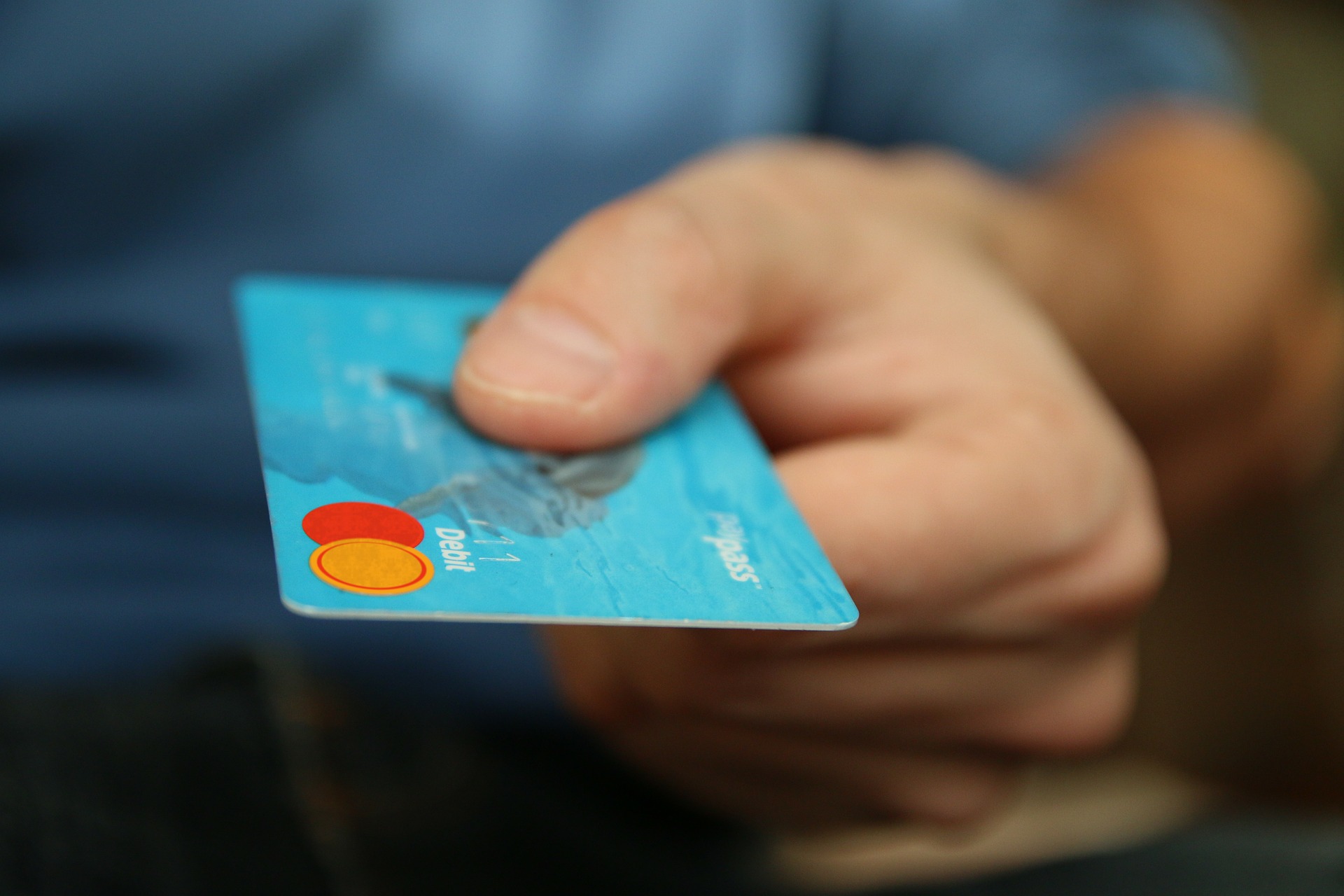 Imagem de homem segurando um cartão de crédito
