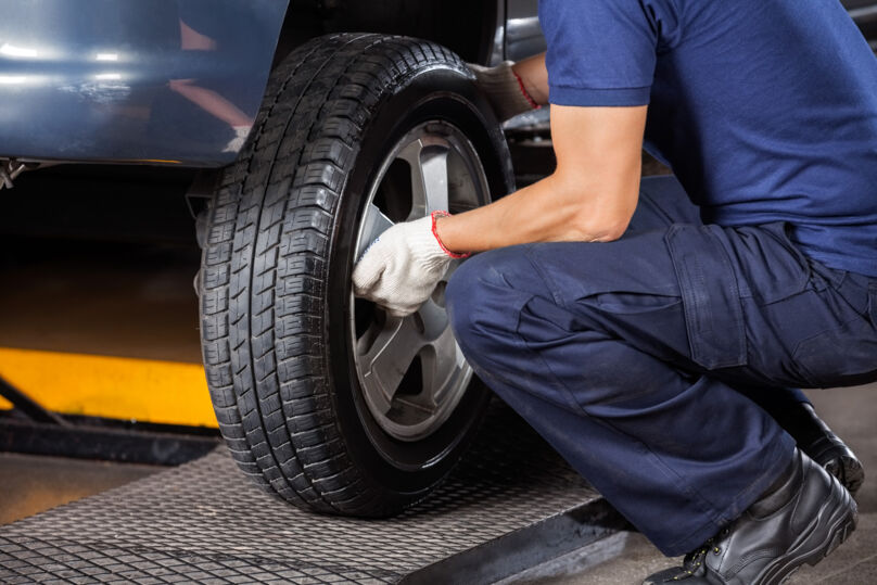 Imagem: mecânico removendo pneu de carro