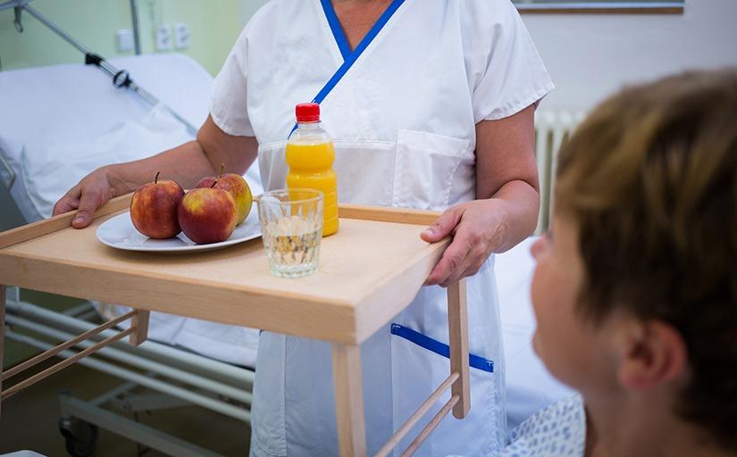 Imagem: enfermeira trazendo refeição para paciente