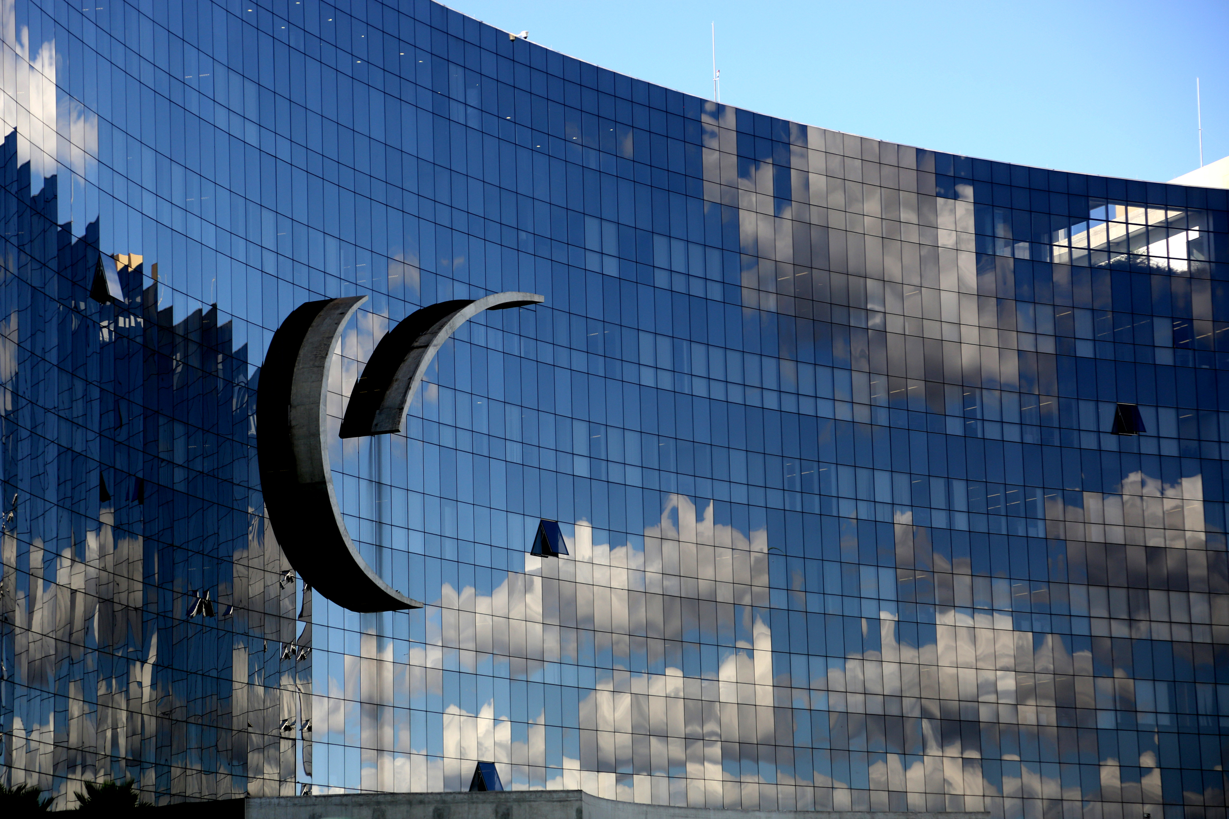 Fachada de vidro do edifício-sede do TST e do CSJT refletindo as nuvens. (Foto: Secom/TST)