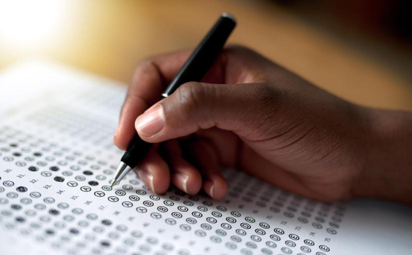  foto ilustrativa recortada de pessoa negra preenchendo um questionário de múltipla escolha