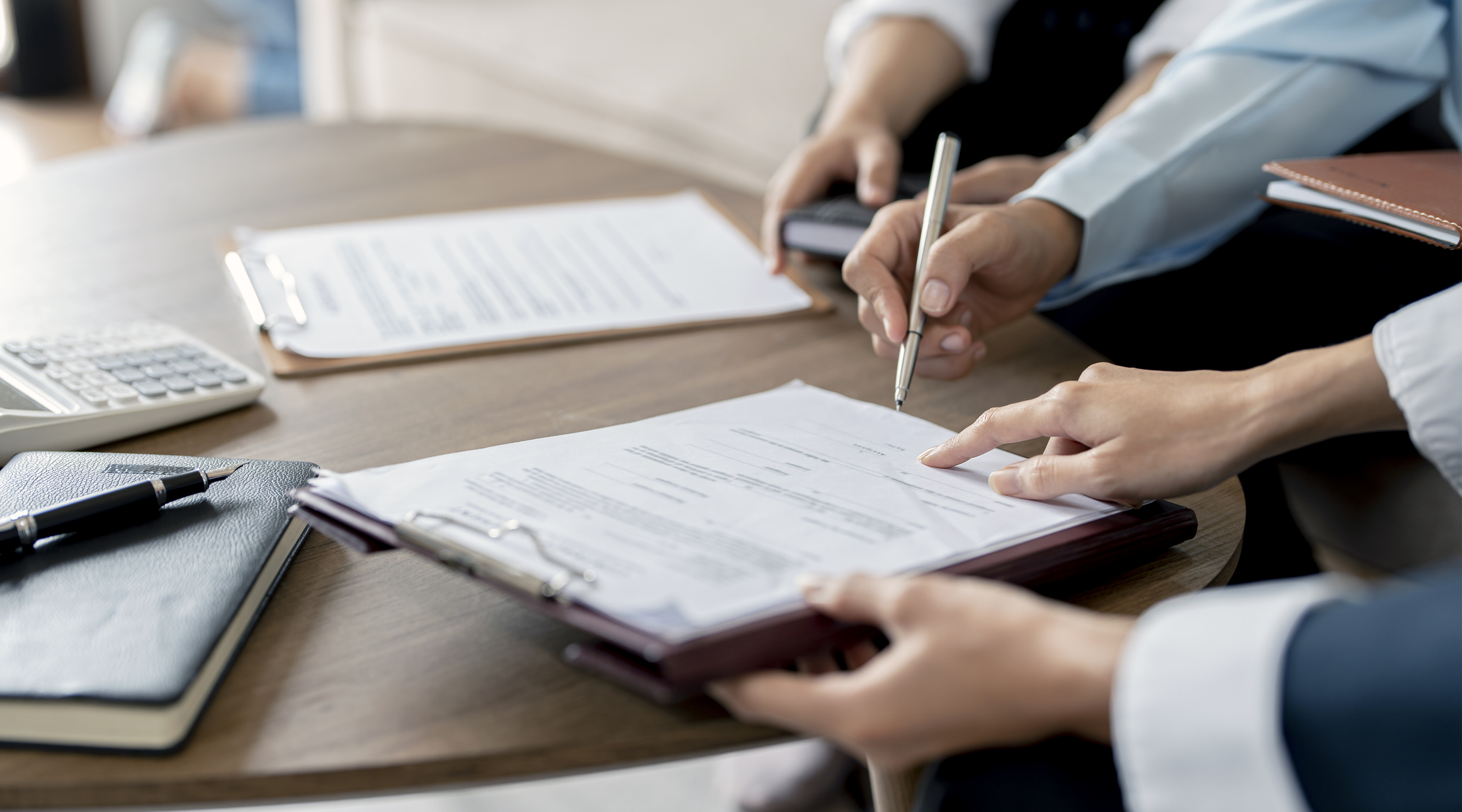 Na imagem, pessoa assinando documentos