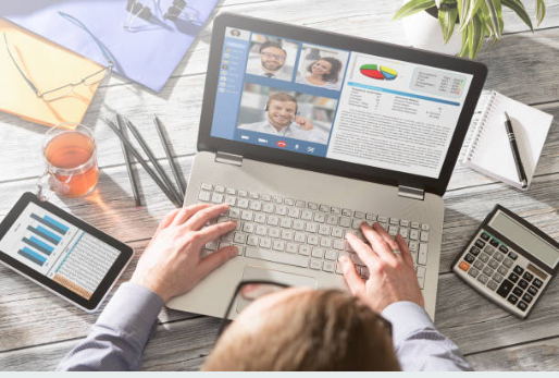 Pessoa usando um computador enquanto realiza tarefas do trabalho.