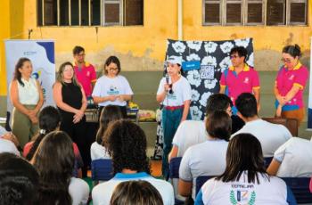 Fotografia com algumas pessoas sentadas e algumas em pé.