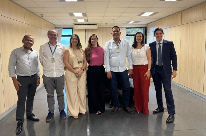 Fotografia com a presença de 7 pessoas, sendo 4 homens e 3 mulheres, todos usando roupa social.