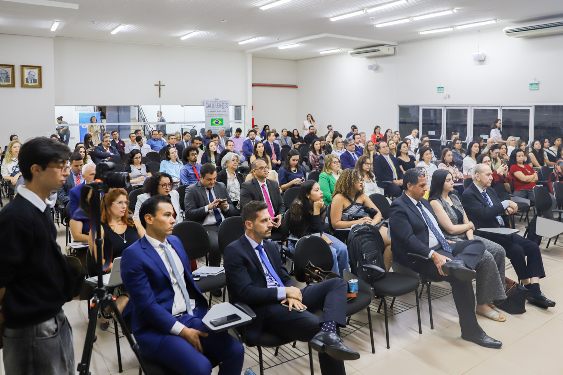 Esta é a imagem de uma plateia atenta em um auditório ou sala de conferências.