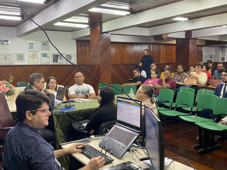 Foto colorida do auditório da Unama durante a audiência, com diversos alunos na plateia.