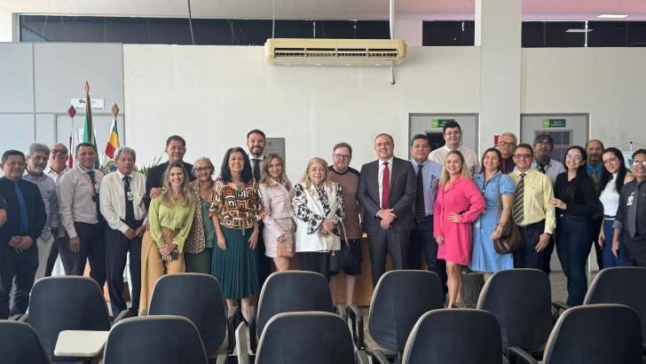 Foto de ambiente fechado que reúne a desembargadora e outros servidores da justiça do trabalho.