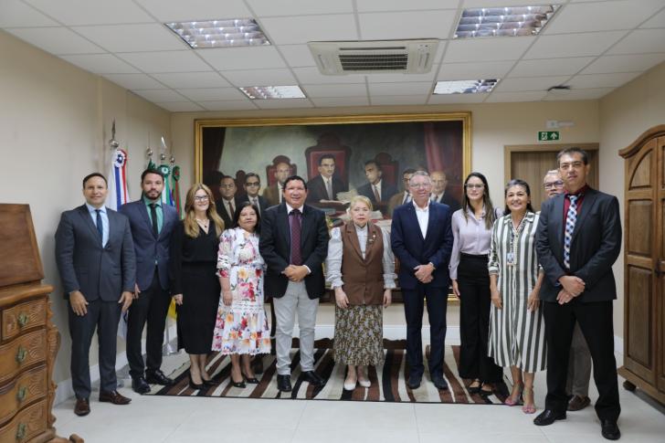 Foto em espaço fechado, com diversas pessoas, entre homens e mulheres.