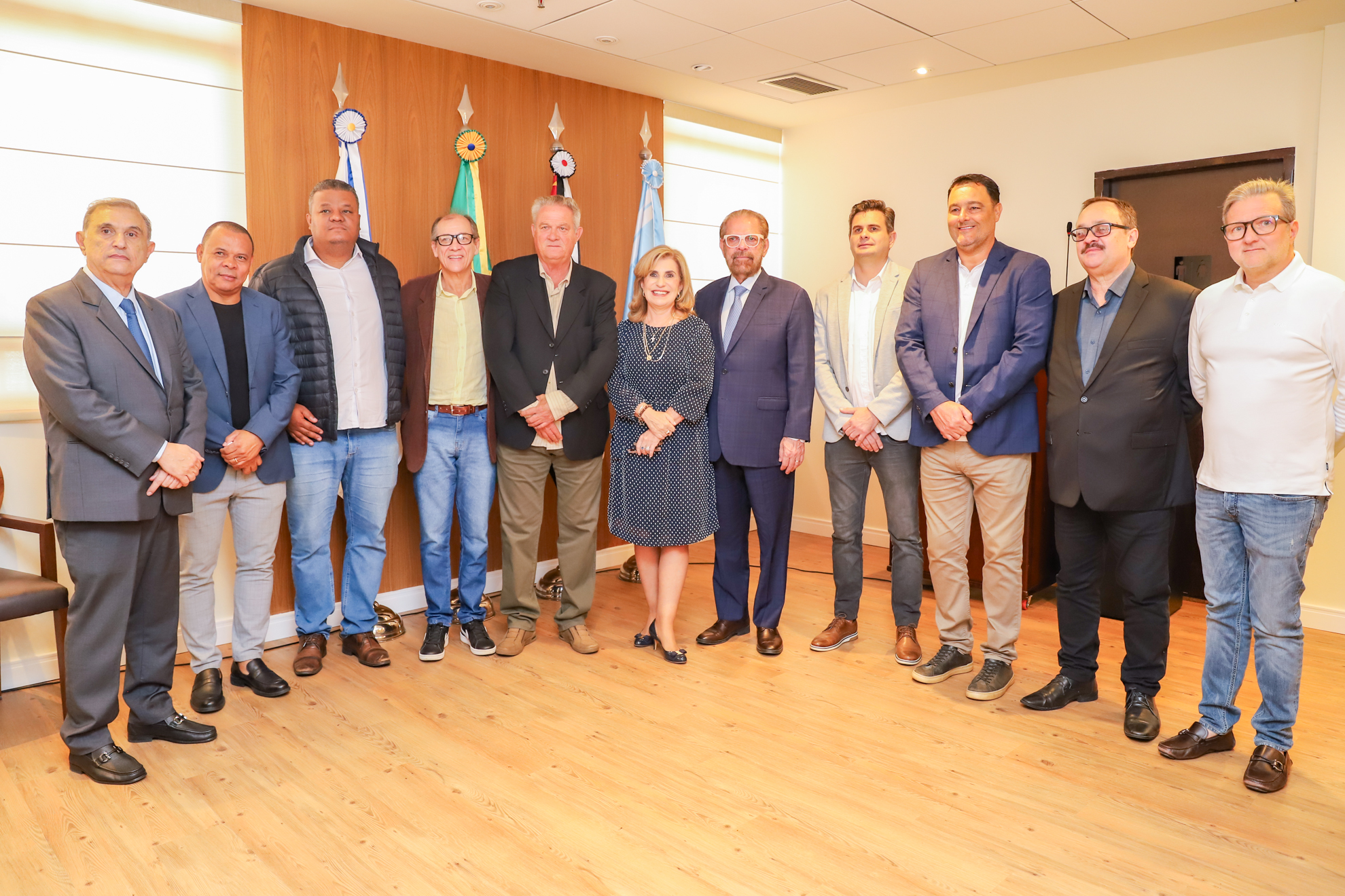 Fotografia com a presença de 11 pessoas, sendo 10 homens e 1 mulher, todos vestidos com roupas mais sociais.