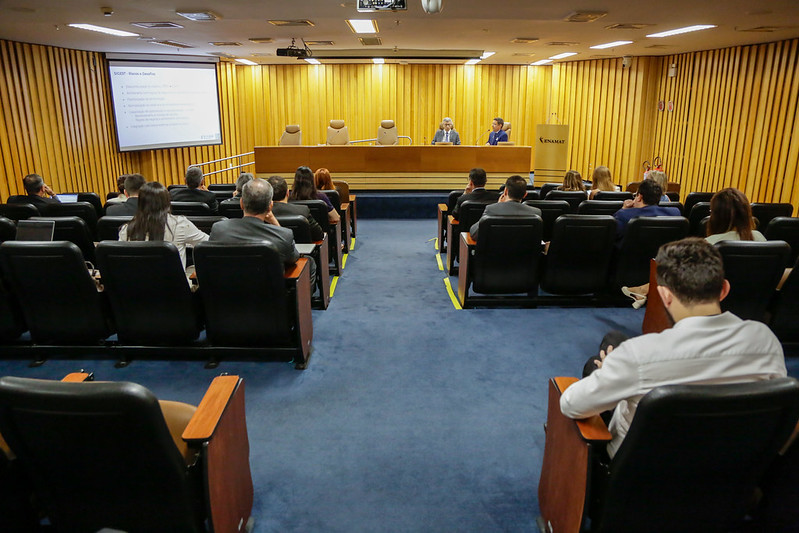 Foto de auditório pequeno com pessoas.