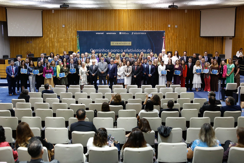 Foto do plenário com as pessoas que receberam os certificados posadas junto de ministros do TST.