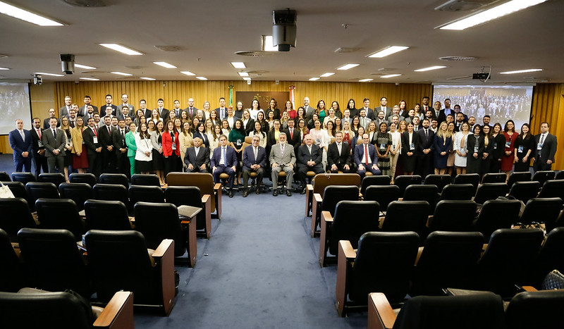 Mais de 200 juízas e juízes posando para a foto junto de ministros do TST no auditório. 