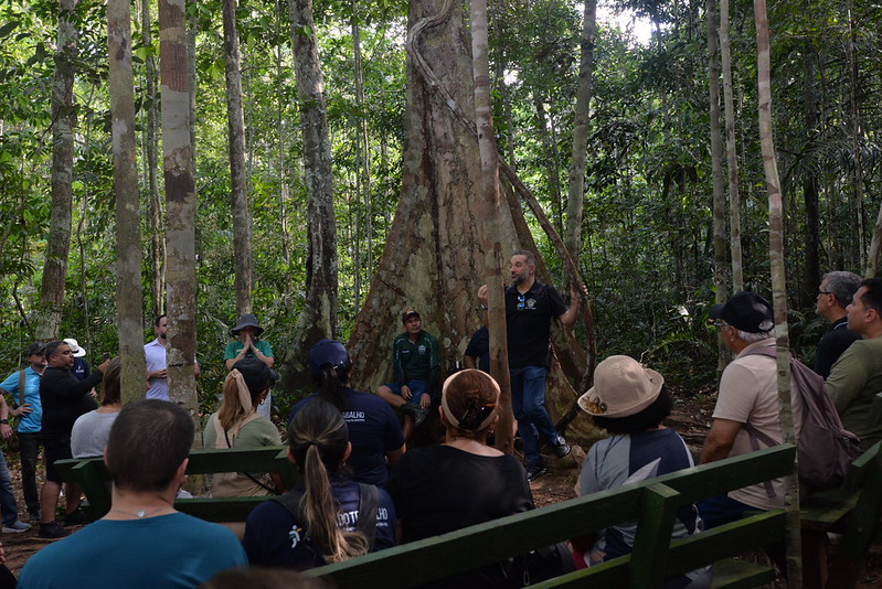 Foto dos representantes da Justiça do Trabalho no meio da Floresta em uma apresentação da comunidade.