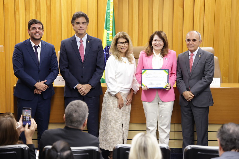 Fotos dos ministro posados com duas desembargadoras no auditório.