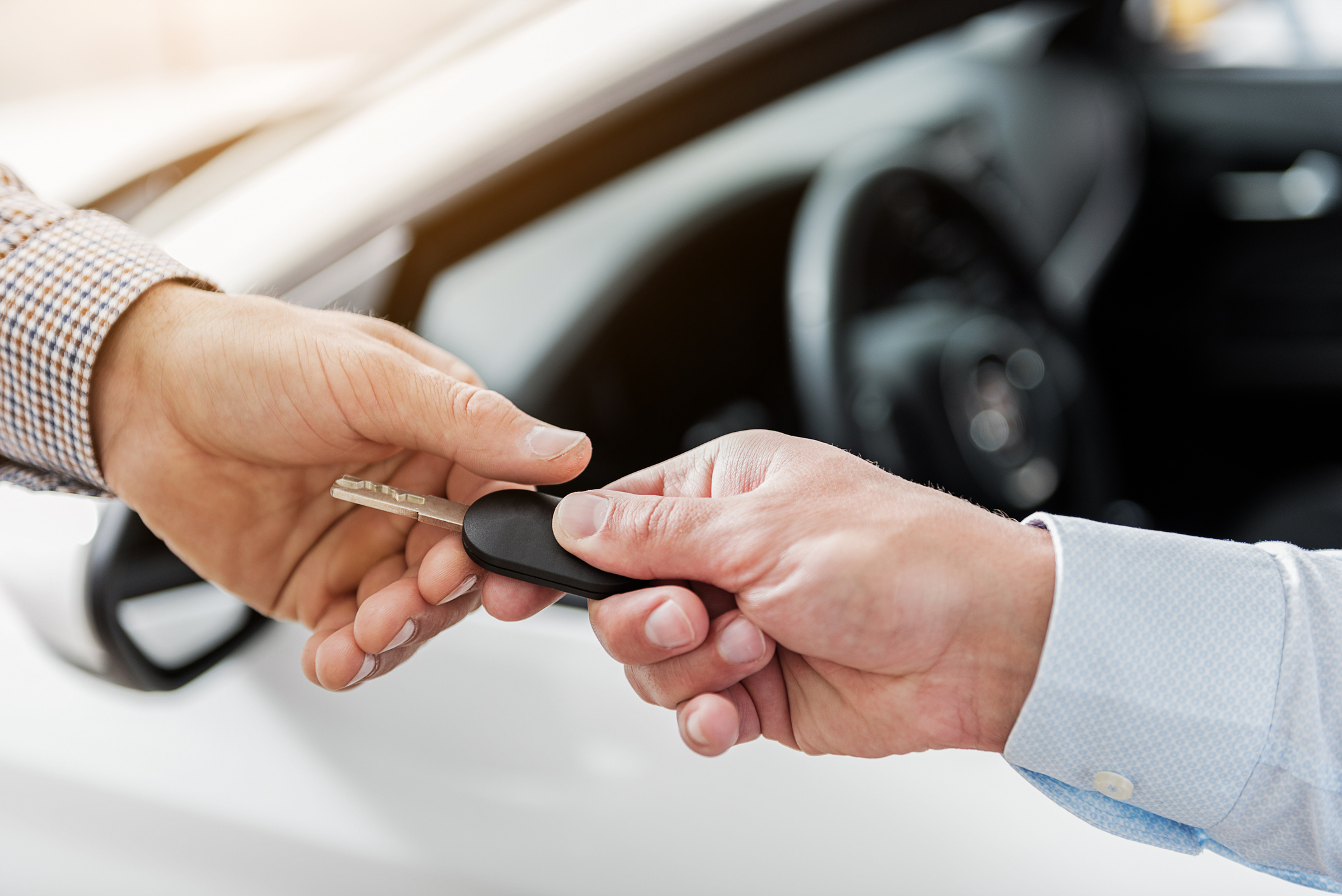 Imagem de um pessoa entregando a chave de um carro para outra pessoa