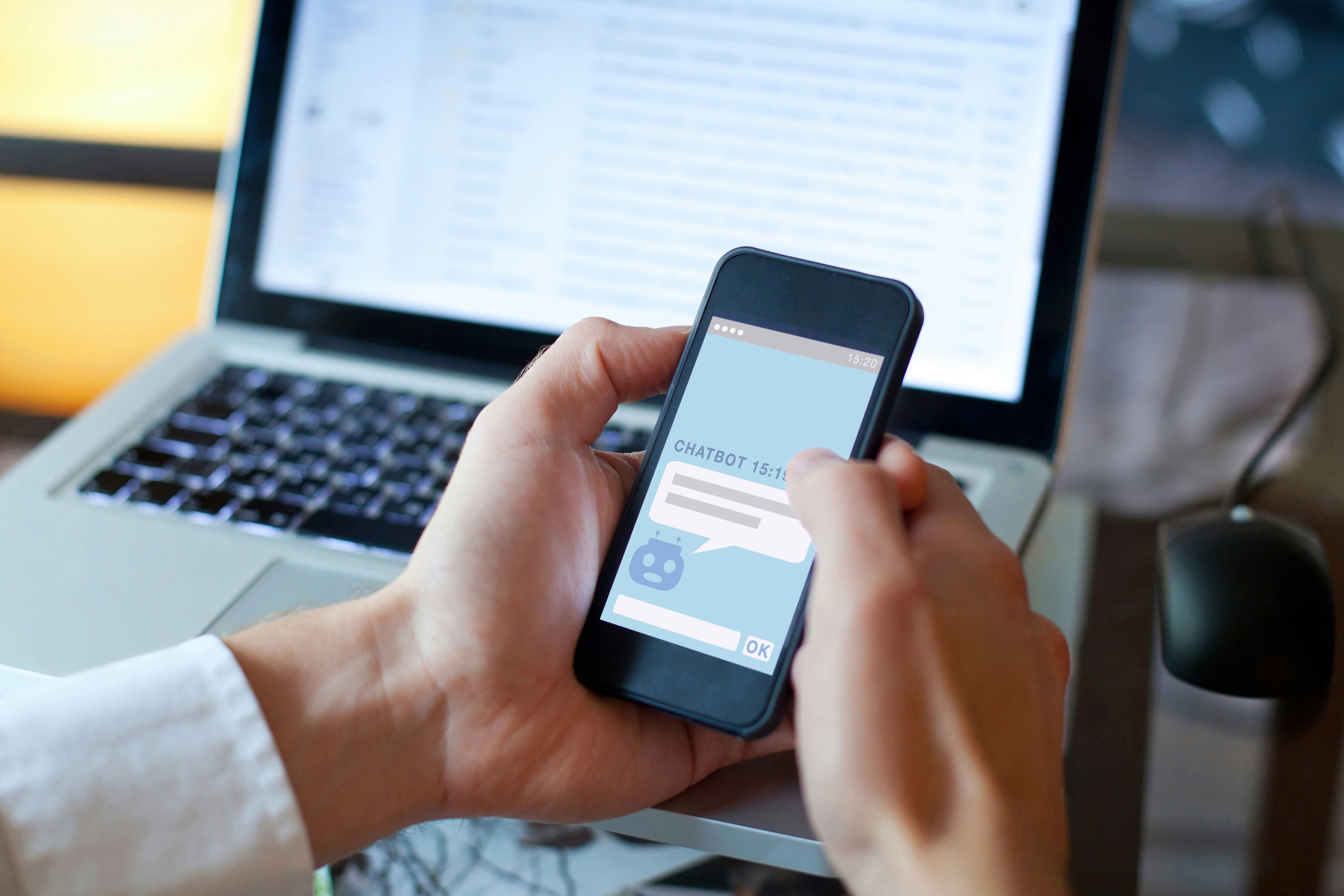 Pessoa segurando um telefone com ChatBot escrito