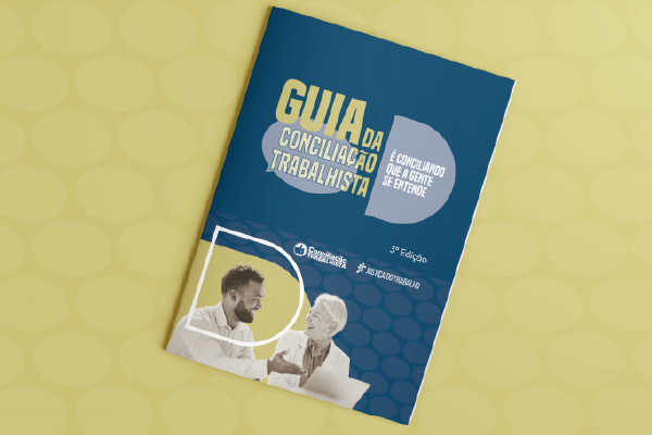 Mockup da cartilha, que tem a cor azul e Ilustração com ícones de balão de diálogo em tons de azul. Está escrito: Guia da Conciliação Trabalhista - É Conciliação que a gente se entende. Abaixo um homem e uma mulher conversando