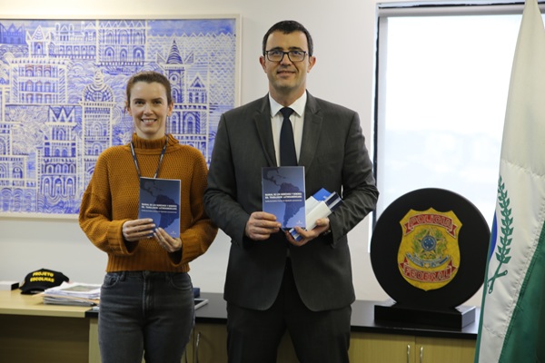 O delegado superintendente regional substituto da PF no Paraná, Julio Rodolfo Kummer, e a delegada-chefe da Delemig, Silvia Cenzollo Peloi, receberam as cartilhas produzidas pelo TRT-PR para distribuir nas delegacias do estado.