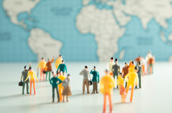 Conjunto de pessoas em miniatura em volta de um globo para representar a criação de uma unidade de monitoramento de decisões no TRT-21 (RN)