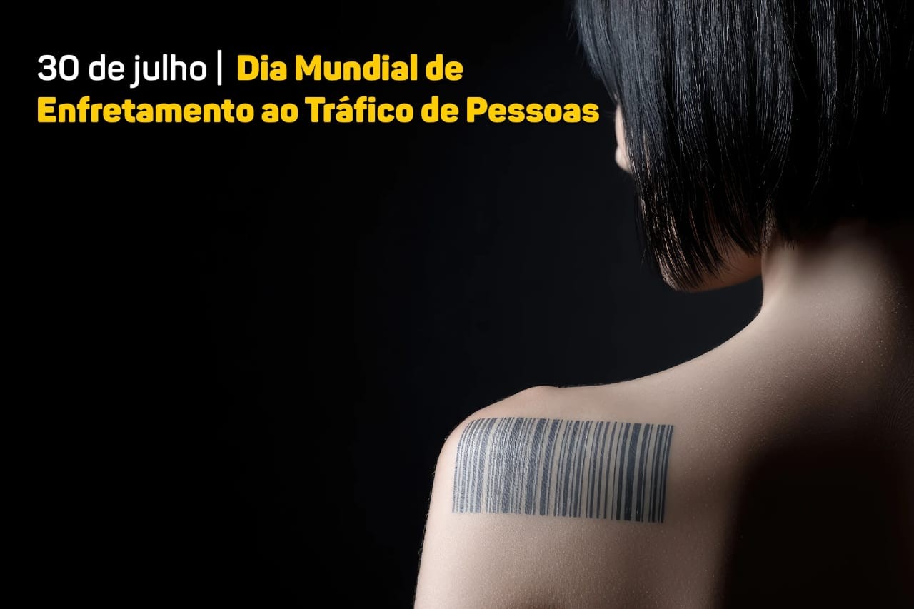 Foto com close do ombro de uma mulher de cabelos curtos contra um fundo preto. No ombro, ela tem tatuado um código de barras. No canto superior esquerdo, o texto