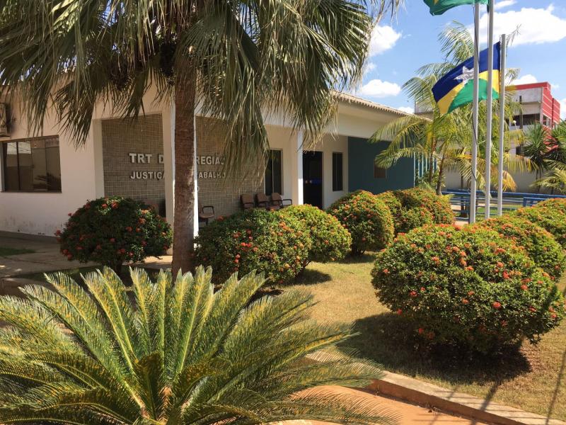 Fotografia do TRT-14 com o verde da paisagem e as bandeiras dos Estados ao lado.