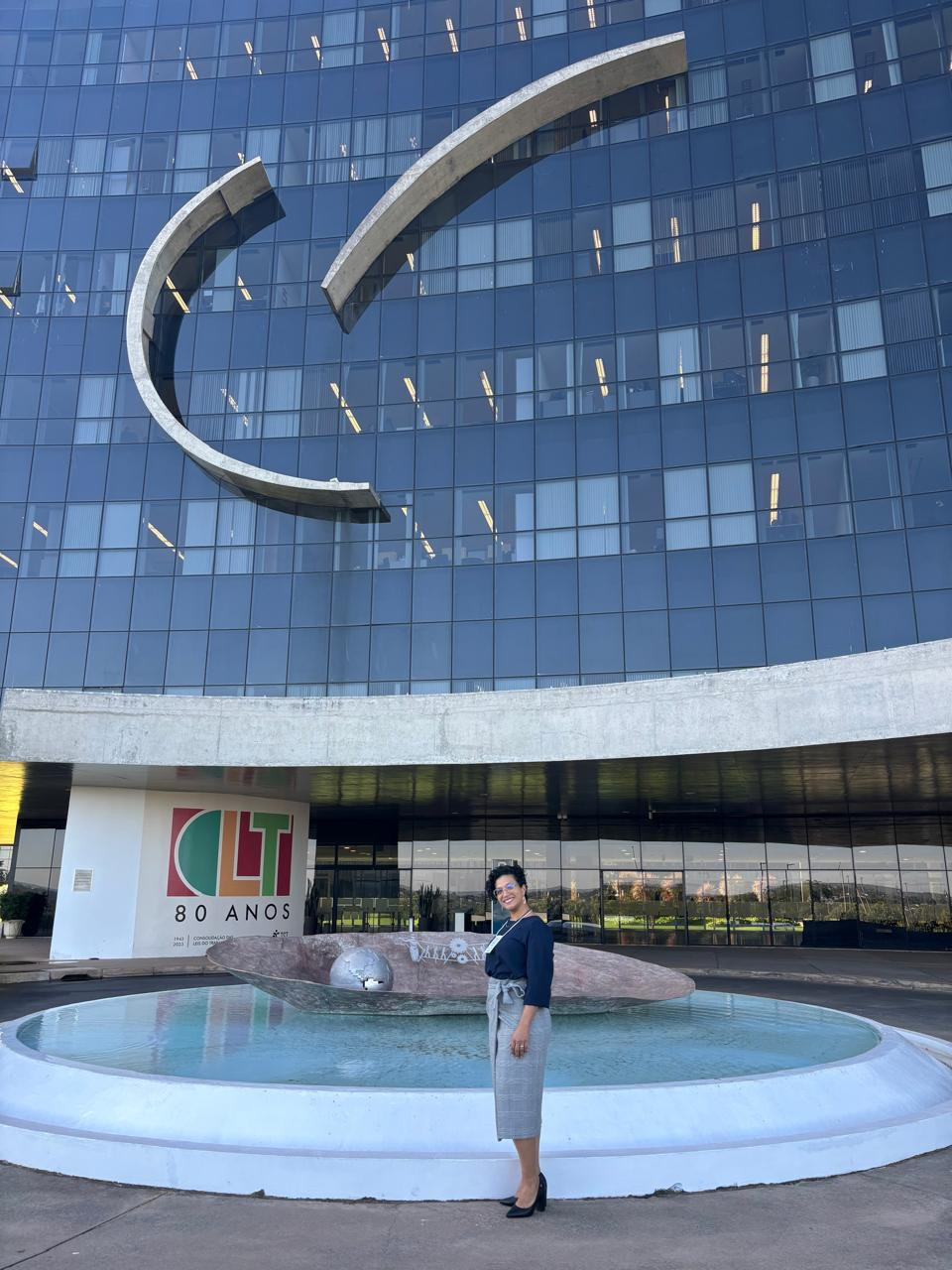 Josiane posando na frente da entrada do TST. 