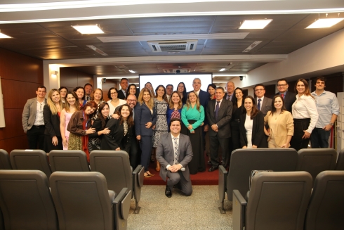 Foto do auditório com as pessoas que participaram posando para a foto.