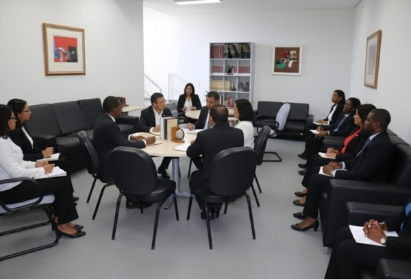 Fotografia de uma sala de reunião com diversas pessoas sentadas.