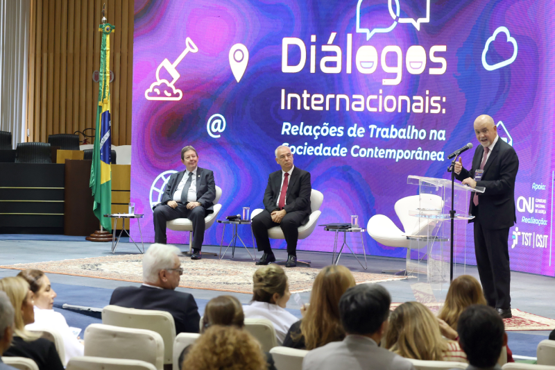 Foto do professor João Leal Amado em púlpito falando para o público no plenário.