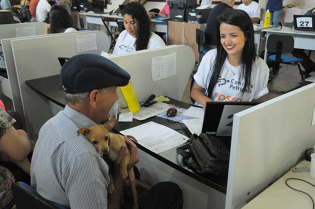 Foto de senhor segurando cachorrinho durante atendimento em mutirão do judiciário