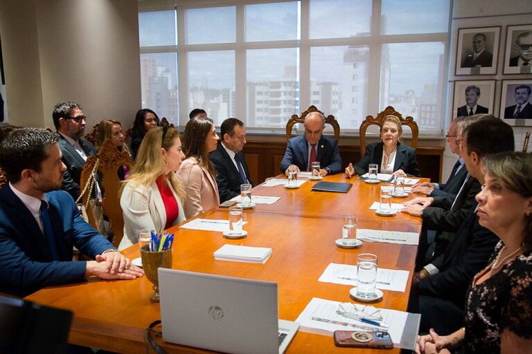 Fotografia de uma mesa com diversos servidores debatendo sobre cooperação judicial no TRT-3 (MG).