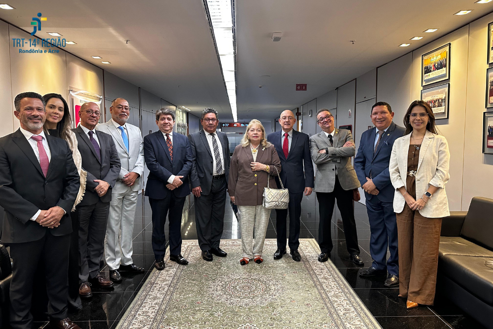 Fotografia com a presença de 11 pessoas, 8 homens e 3 mulheres, em frente a um tapete.