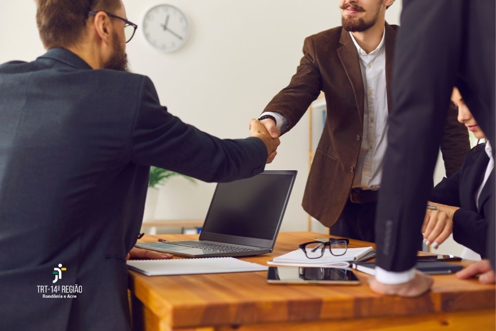 Imagem de duas pessoas apertando as mãos como destaque da fotografia.