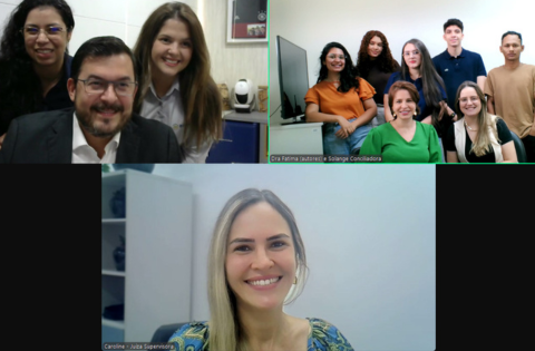 Pessoas reunidas em videoconferência, divididas em três telas, todas sorrindo para a câmera.
