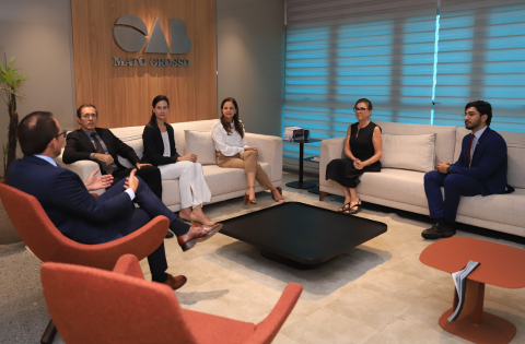 Fotografia com a presença de 6 pessoas, sendo 3 homens e 3 mulheres, sentados em sofás e poltronas na OAB do Mato Grosso.