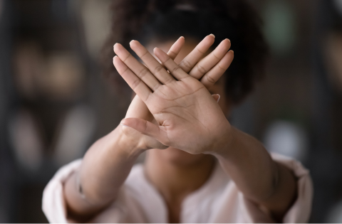 Imagem de uma mulher com as mãos na frente para tampar o rosto.