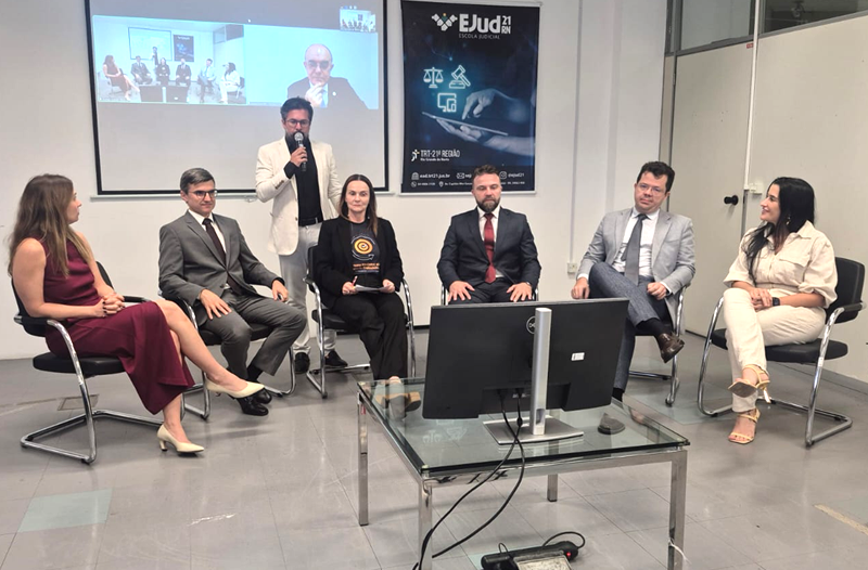 Foto do local de encerramento com os gestores da comissão de execução e o ministro Cláudio em um telão ao fundo.