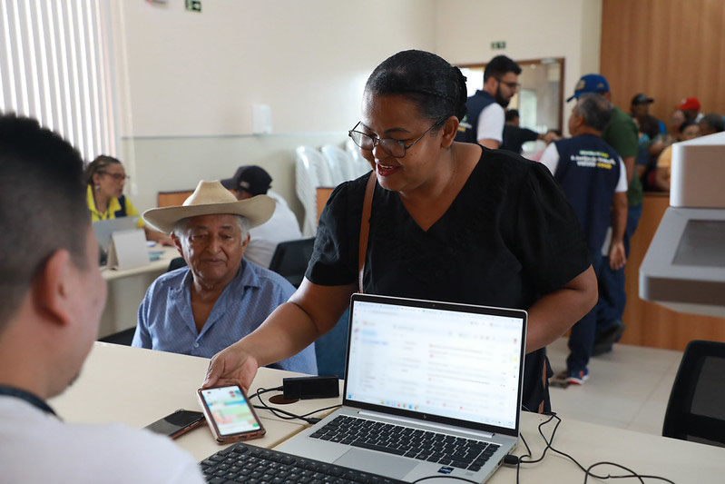 Foto de itinerância real. Uma senhora apresenta a tela do celular para um atendente da Justiça do Trabalho na 8ª Região (PA/AP)