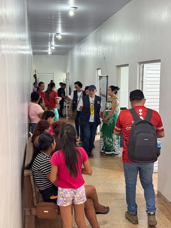 Pessoas em fila esperando para entrar na sala para receber atendimento