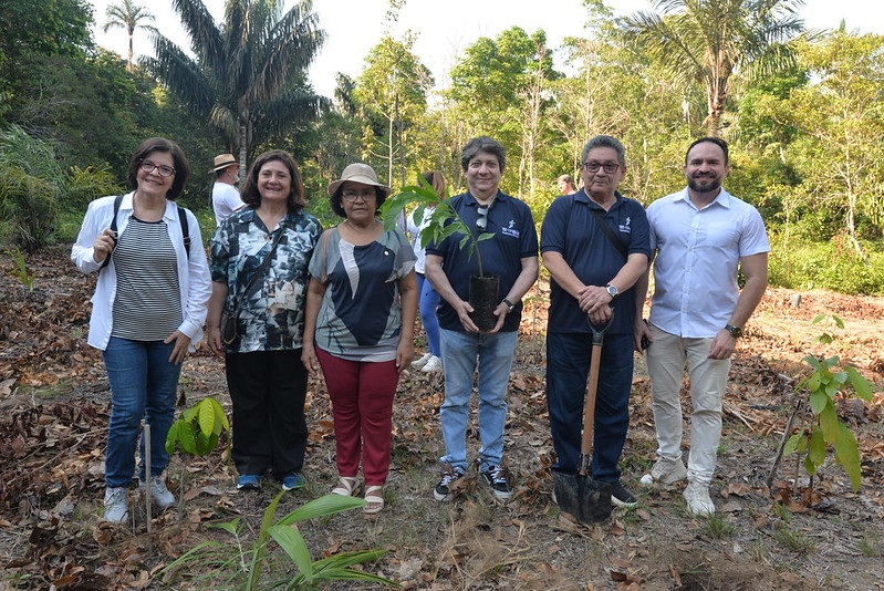 Comitiva da Justiça do Trabalho posando com mudar plantadas durante a visita