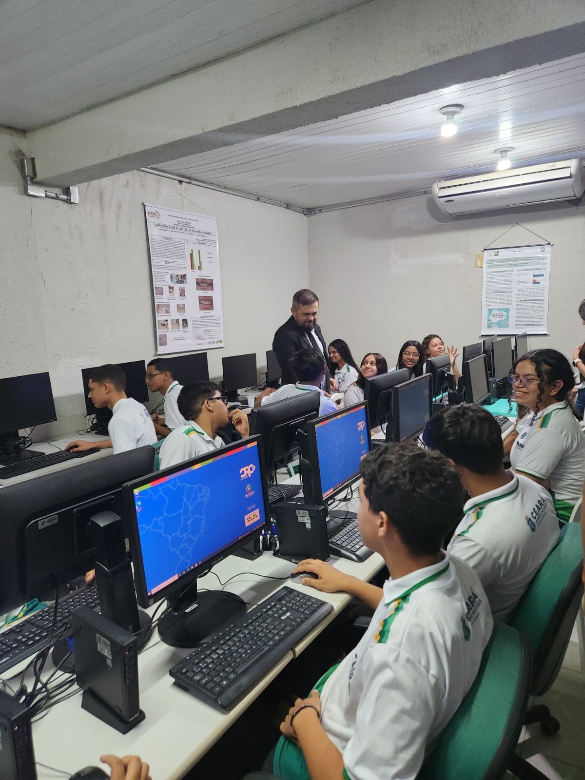 Foto dos estudantes usando os computadores no laboratório inaugurado.